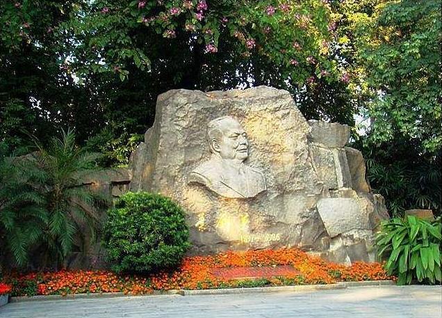 叶剑英元帅墓，位于广州起义烈士陵园，墓地鲜花簇拥，大石为墓碑